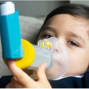 Criança utilizando inalador para o tratamento de asma, uma das doenças respiratórias infantis.
